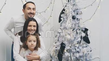 可爱的一家人在圣诞节早上到处玩耍，有趣的父母和女儿都呆在他们的头上